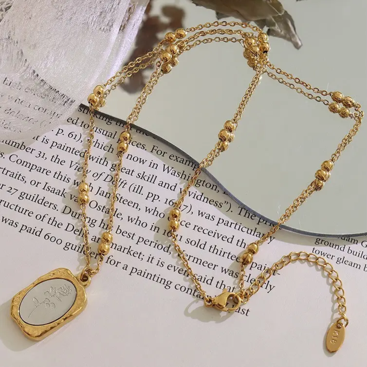 Gold necklace with a pendant on an open book